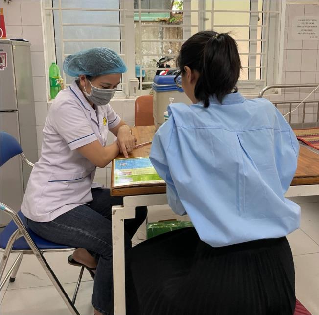 Cán bộ y tế Trạm y tế phường Thạc Gián tư vấn cho đối tượng tiêm chủng